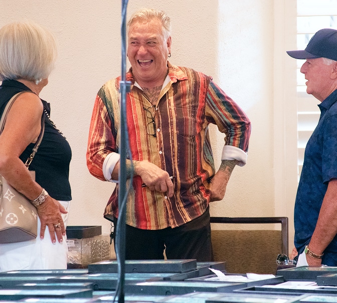 Three adults talking and laughing at a jewelry display